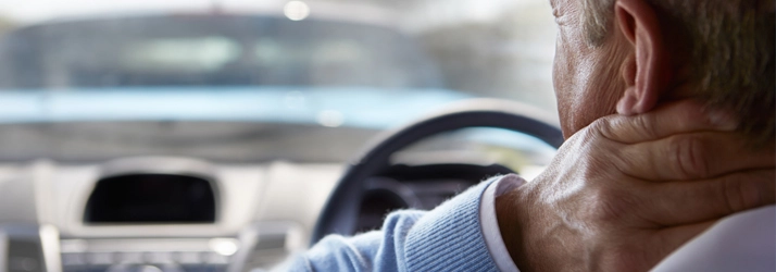 Chiropractic Bakersfield CA Neck Pain Man In Car Person in a care with neck pain.
